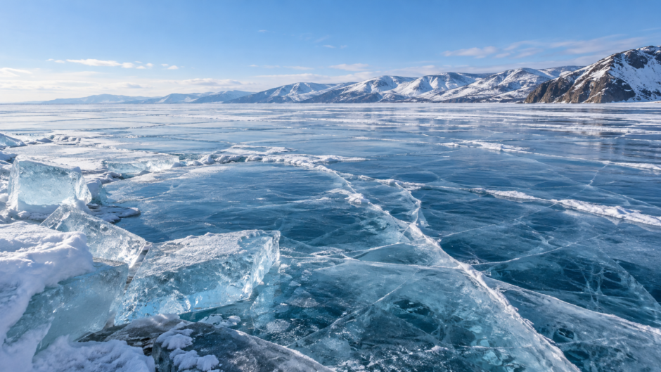 青みを帯びた透明な湖面の氷と亀裂が広がる冬のバイカル湖