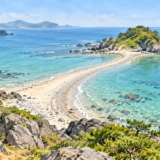 干潮時に海岸と小島をつなぐ砂と小石のトンボロ